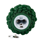 Underside of the green pinecone candle showing an empty white battery compartment and small slide switch, with the removed cover and spring contact below.