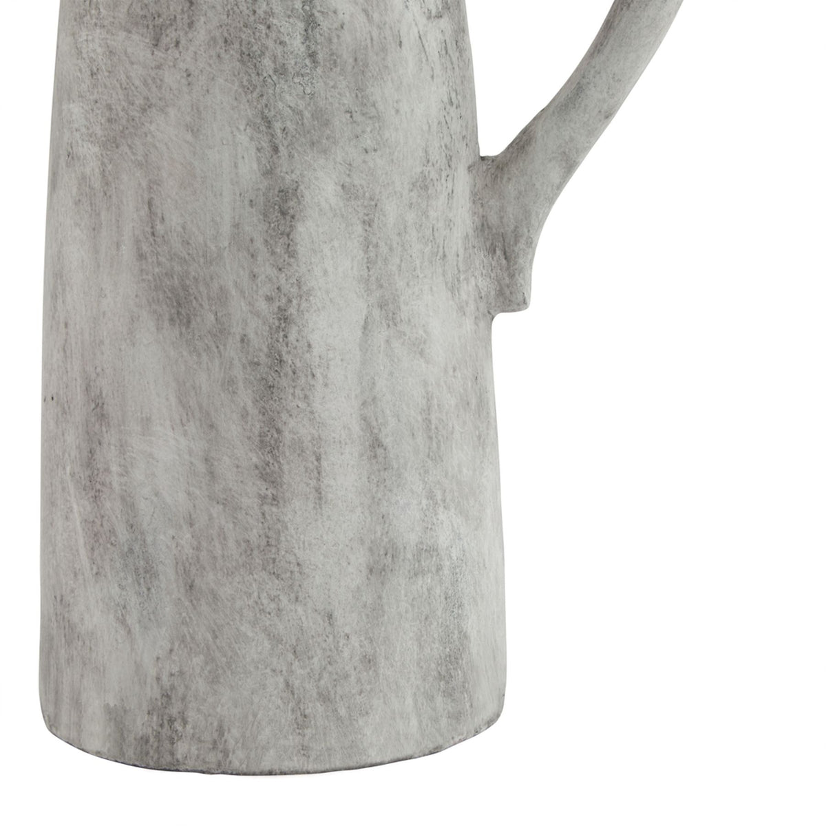 Detail of the jug lower body and base, with grey mottling across the pale surface and the lower handle attachment visible.