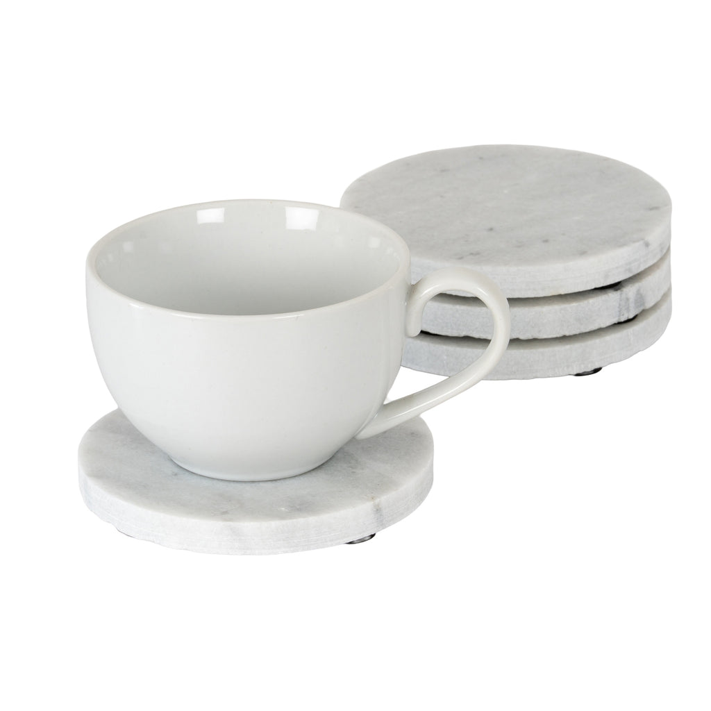 White cup on a pale mottled round coaster, with three matching coasters stacked behind and small black underside pads visible.