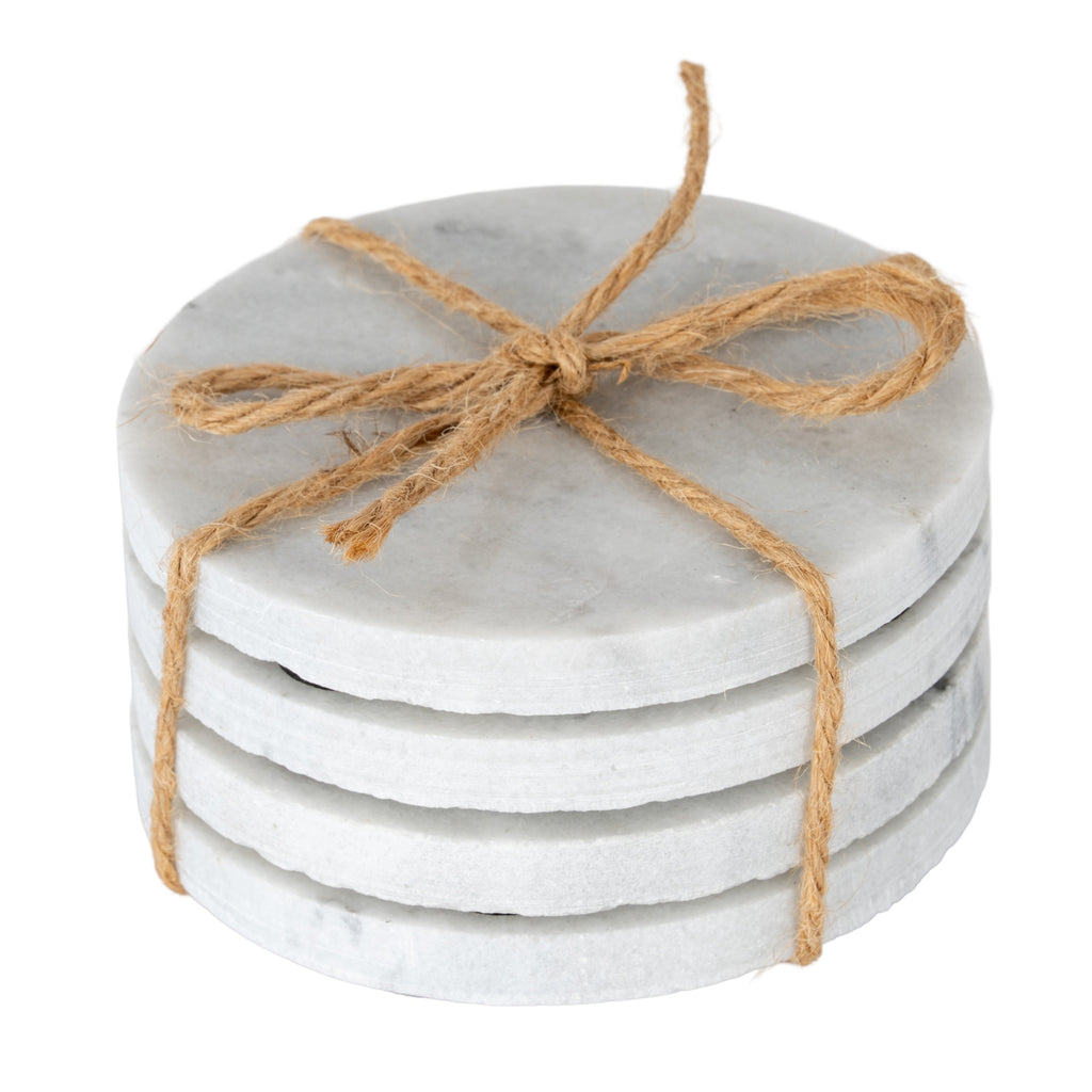 Four pale round coasters stacked and tied with a brown cord bow, showing faint grey mottling and rough edges.