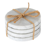 Four pale round coasters stacked and tied with a brown cord bow, showing faint grey mottling and rough edges.