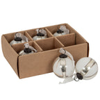 Pale panelled baubles in a divided brown tray, with two ornaments placed in front showing reflective ribs, dark caps and white sheer ribbons.