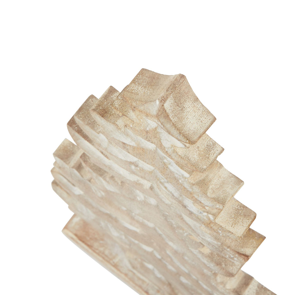 Angled close-up of the tree's upper tiers showing recessed curves, textured grain and white accents.