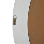 Rear detail of the mirror showing the pale frame, brown backing, small retaining tabs and a metal loop hanger attached with three screws.