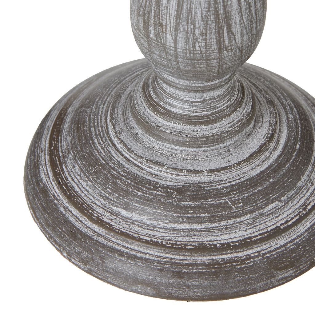 Detail of the lamp's broad circular foot, with concentric ridges and pale rubbed marks around the lower column.