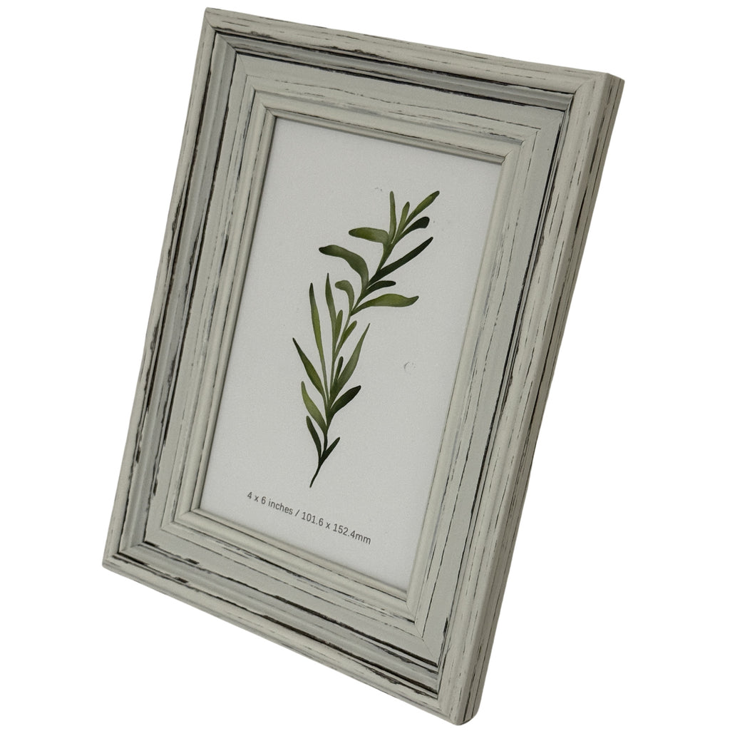 Angled front view of the pale layered photo frame, showing the depth of its right edge and a green leafy insert.