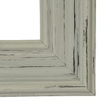 Close-up of a lower frame corner, showing the layered pale moulding and irregular dark lines and patches.