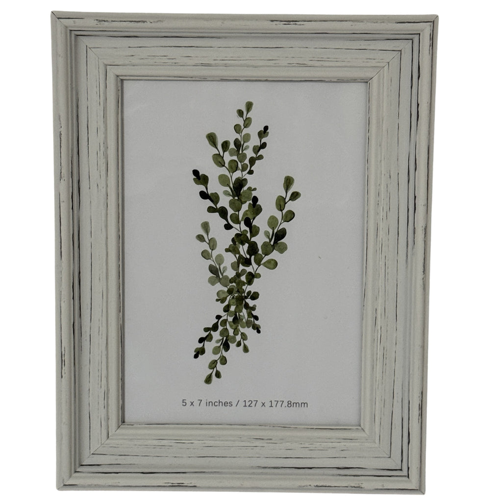 Front view of a pale grey-white layered photo frame with dark rubbed marks and a leafy insert marked 5 × 7 inches.