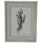 Front view of a pale grey-white layered photo frame with dark rubbed marks and a leafy insert marked 5 × 7 inches.