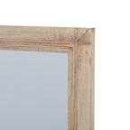 Detail of the mirror's upper right frame corner, with pale grained surfaces and lines running along the inner edge.