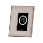 Angled front view of a portrait photo frame with a broad pale wood-effect border, darker stepped edging and a black display insert.