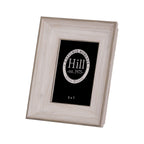 Angled front view of a portrait photo frame with a broad stepped pale white-grey wood-effect border and black display insert.