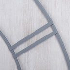 Close-up of grey metal numeral bars and curved dial lines over the streaked whitewashed panel surface.