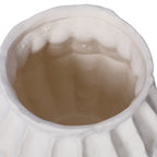 Close view into the white ceramic vase, showing its wavering rim and slightly irregular interior surface.