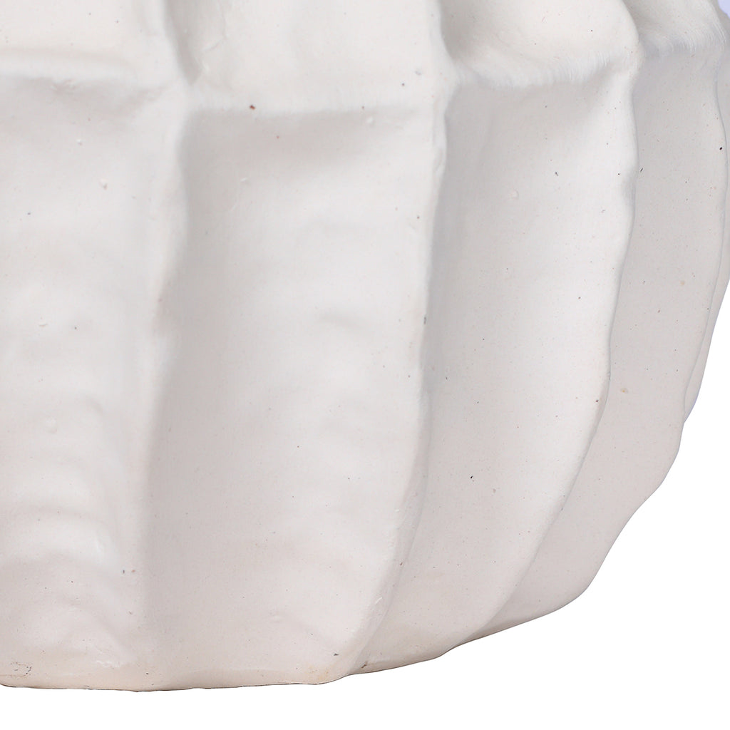 Detail of the vase's lower panelled sides, showing the matte-white texture and small surface irregularities.