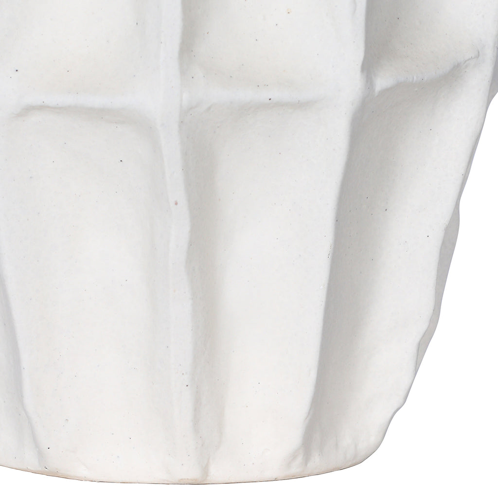 Detail of the vase's lower body, showing softly raised panels and fine speckling in the matte-white surface.