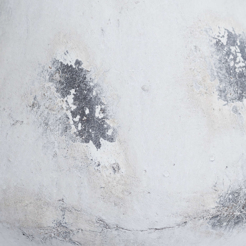 Close-up of the vase's chalky white surface, showing dark grey distressed patches and fine uneven markings.