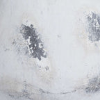Close-up of the vase's chalky white surface, showing dark grey distressed patches and fine uneven markings.