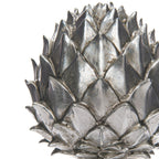Close-up of the pinecone finial's layered pointed scales, showing bright silver-coloured ridges and darker mottled recesses.