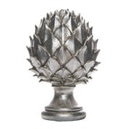 Silver-coloured pinecone finial with overlapping pointed scales, a narrow neck and rounded stepped pedestal base on a white background.