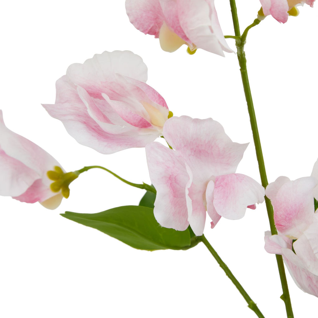 Close-up of loosely folded pink and white artificial petals with yellow-green flower bases, branching green stems and a leaf beneath the blooms.