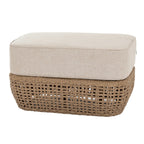 Piped Basketfoot Footstool shown at an angle, with a thick pale beige cushion above a brown open basket-weave base.