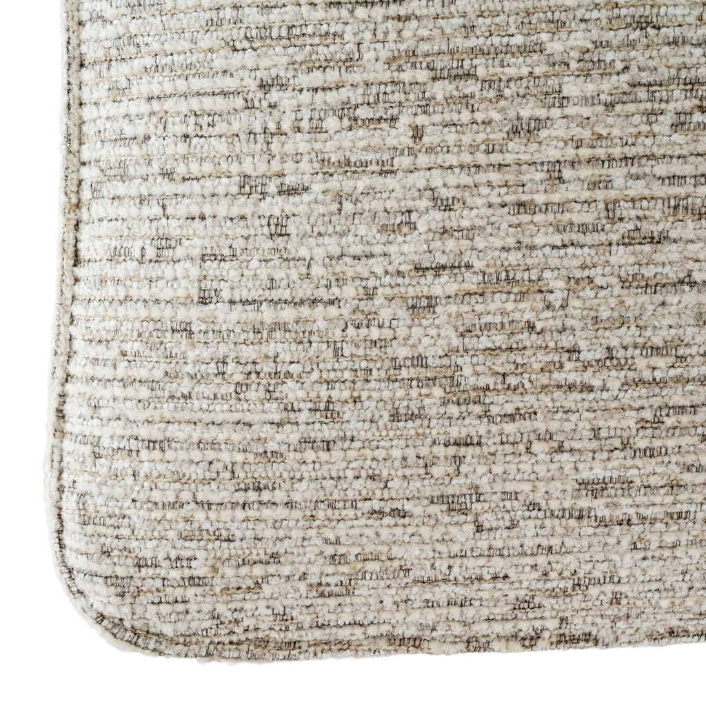 Detail of the mist-grey upholstery with small raised loops, fine contrasting threads and piping around the rounded lower edge.