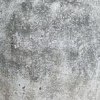 Close-up of the vase's irregular pale mottling, dark pits and earthy patches.