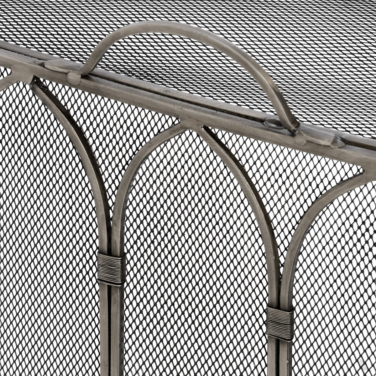 Close-up of the fire screen's curved handle, pointed metal arches and wrapped collars against fine diamond mesh.