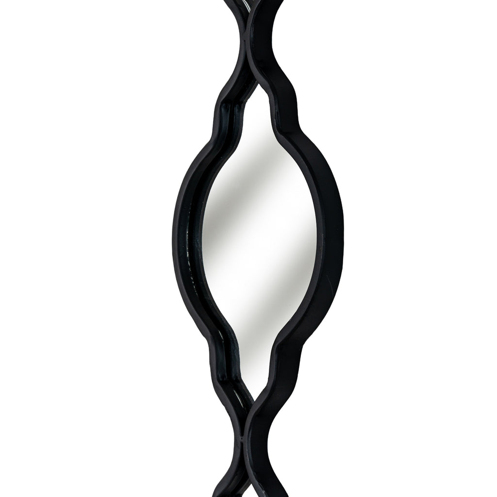 Angled close-up of a mirrored section showing the depth of its black edging around the curved sides and pointed lower end.