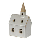 Angled view of the glossy white church decoration with a plain gable on the right and a circular opening beneath the pointed tan spire.