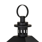 Detail of the black loop ring above the layered circular cap, with elongated slots visible in the cylinder below and the roof edges at the bottom.