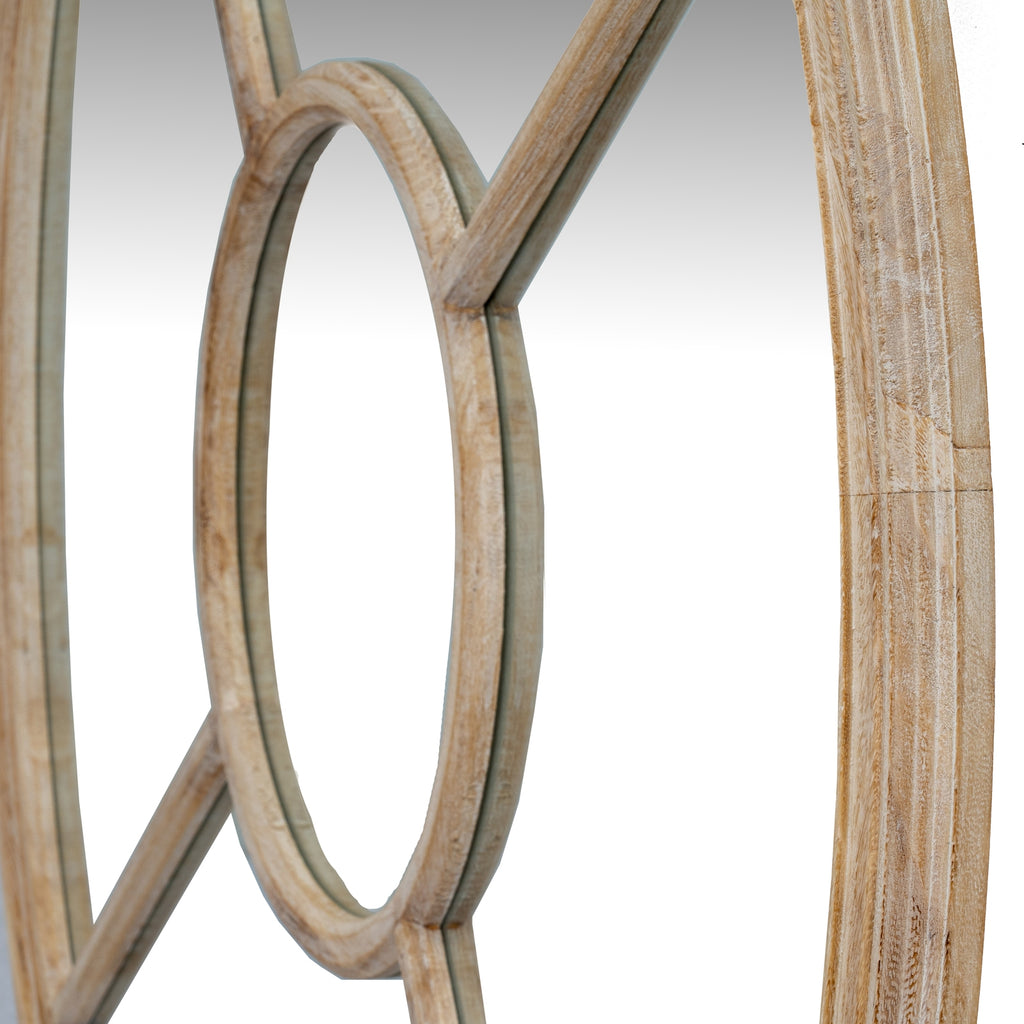Angled close-up of the mirror's central ring and adjoining diagonal bars, with a pale washed wood-tone finish and the curved outer frame visible at the edges.