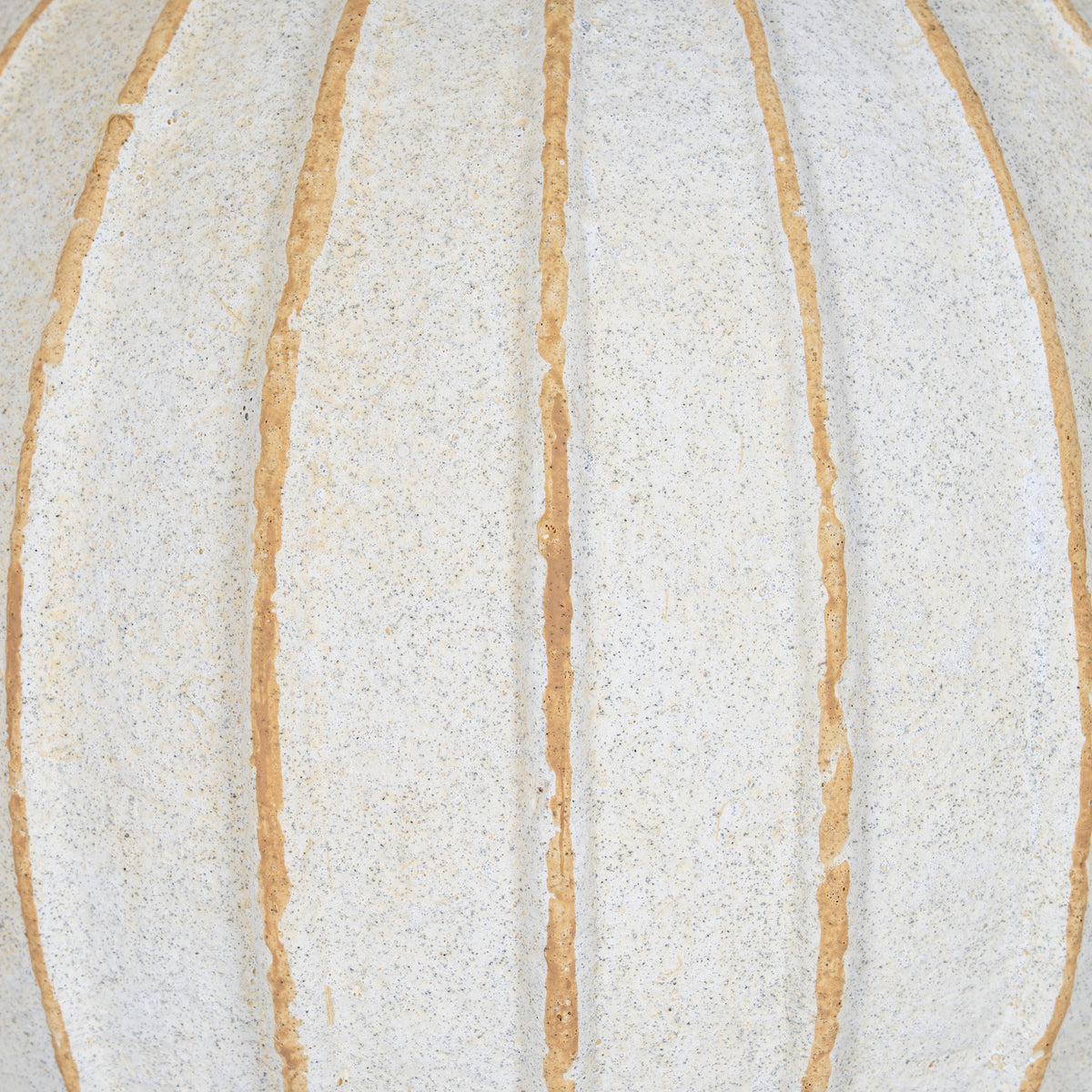 Detail of the vase body showing fine speckling, a granular cream-white surface and uneven tan grooves.