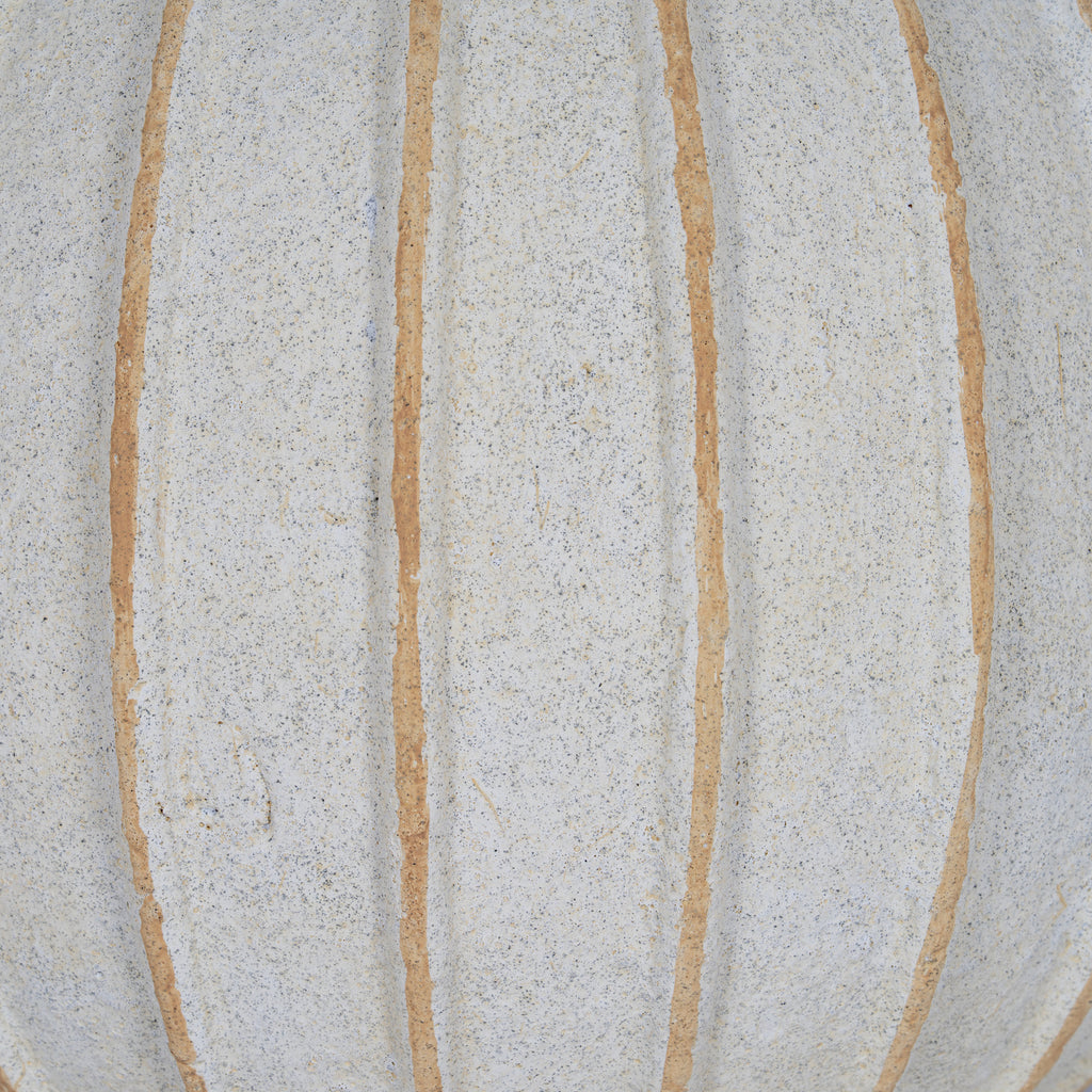 Surface detail of the vase showing uneven tan grooves across the granular, finely speckled cream-white body.