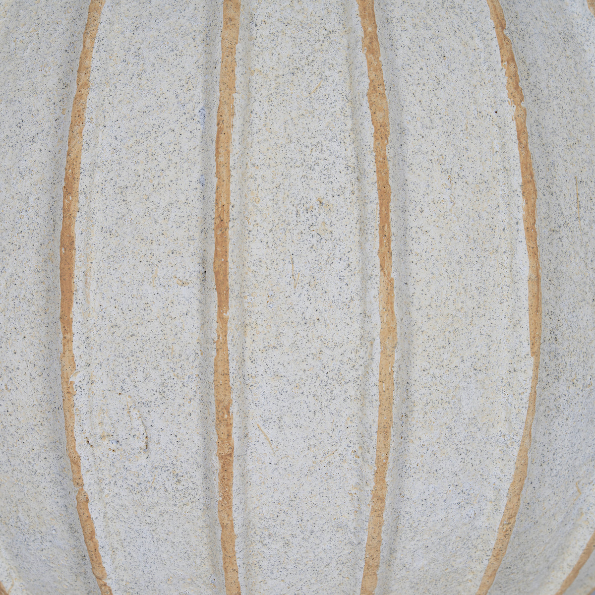 Surface detail of the vase showing uneven tan grooves across the granular, finely speckled cream-white body.