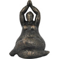 Front view of a bronze-finish seated feminine figure sculpture with folded legs and palms joined overhead.