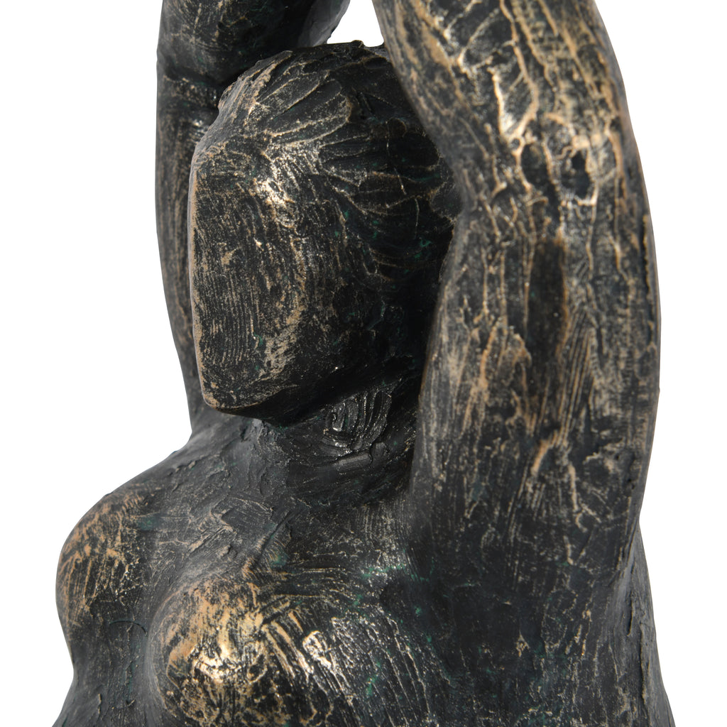 Close-up of the figure's simplified face, sculpted hair and raised arm showing the rough distressed bronze finish.