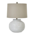 White table lamp with a rounded raised-bead base, pale drum shade and silver-toned finial against a white background.