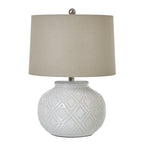 White table lamp with a rounded raised-bead base, pale drum shade and silver-toned finial against a white background.