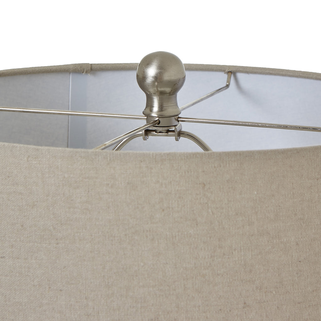 Close view over the neutral woven shade, showing its top rim and the rounded silver-coloured finial at the centre.