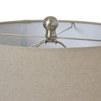 Close view over the neutral woven shade, showing its top rim and the rounded silver-coloured finial at the centre.
