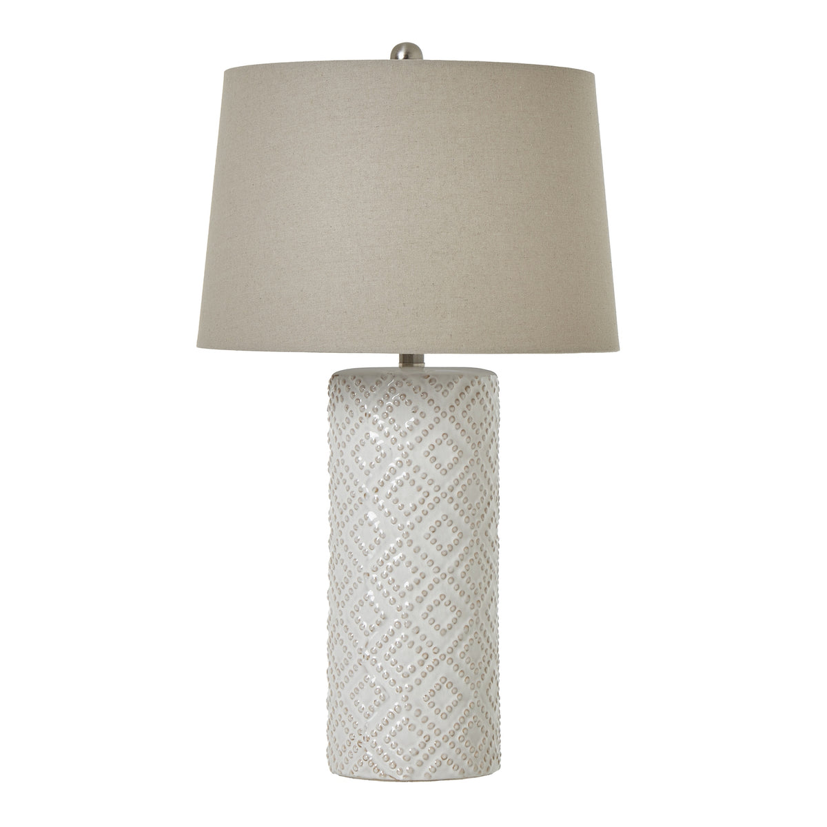 Table lamp with a tall off-white cylindrical base patterned with raised-dot diamonds, a broad neutral tapered shade and rounded silver-coloured finial.