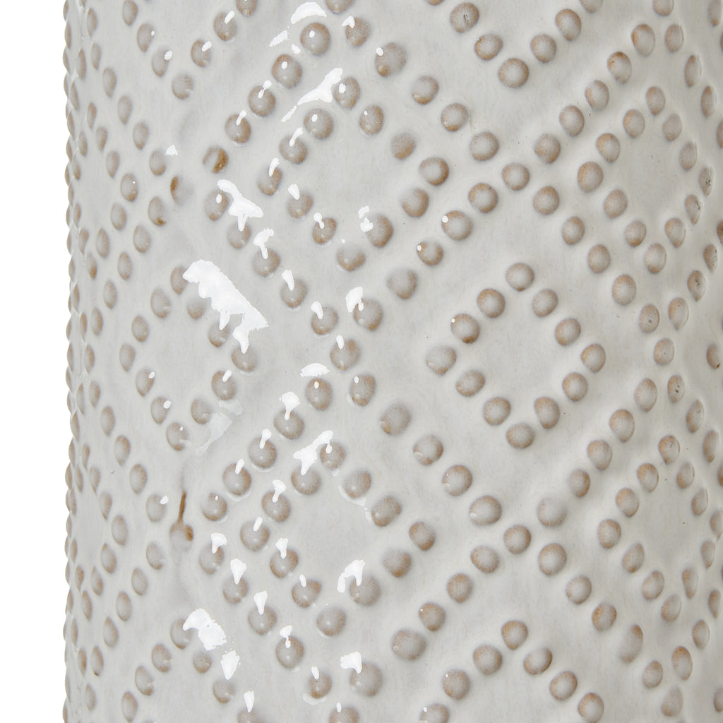 Close-up of the glossy off-white lamp base, showing rounded raised dots in diagonal diamond bands with warm beige shading.