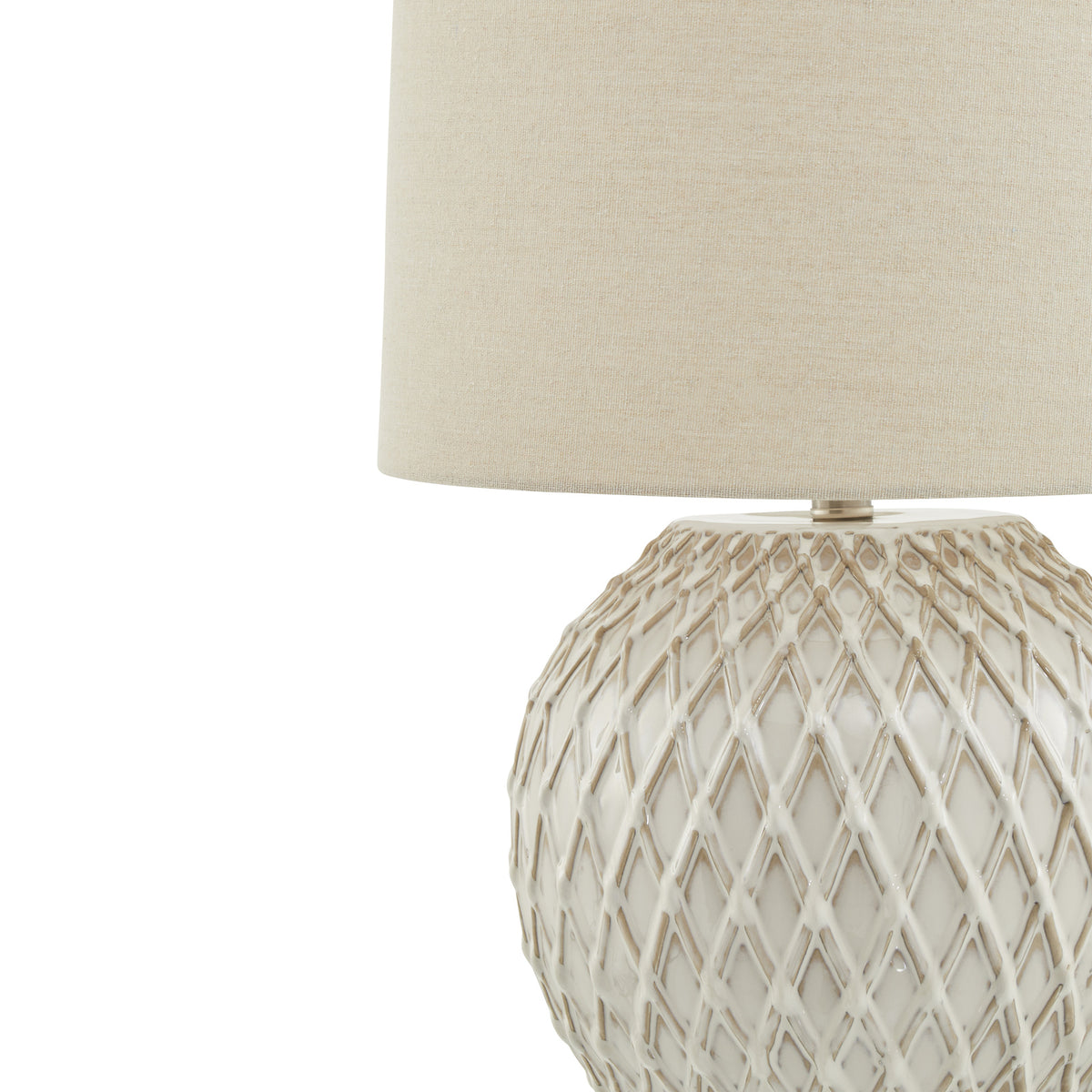 Close view of the lamp's raised cream diamond pattern with beige accents beneath the textured pale shade.