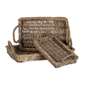 Three brown rectangular woven trays with raised rims and loop handles, arranged with one upright at the back, one flat beneath it and a smaller tray angled in front.