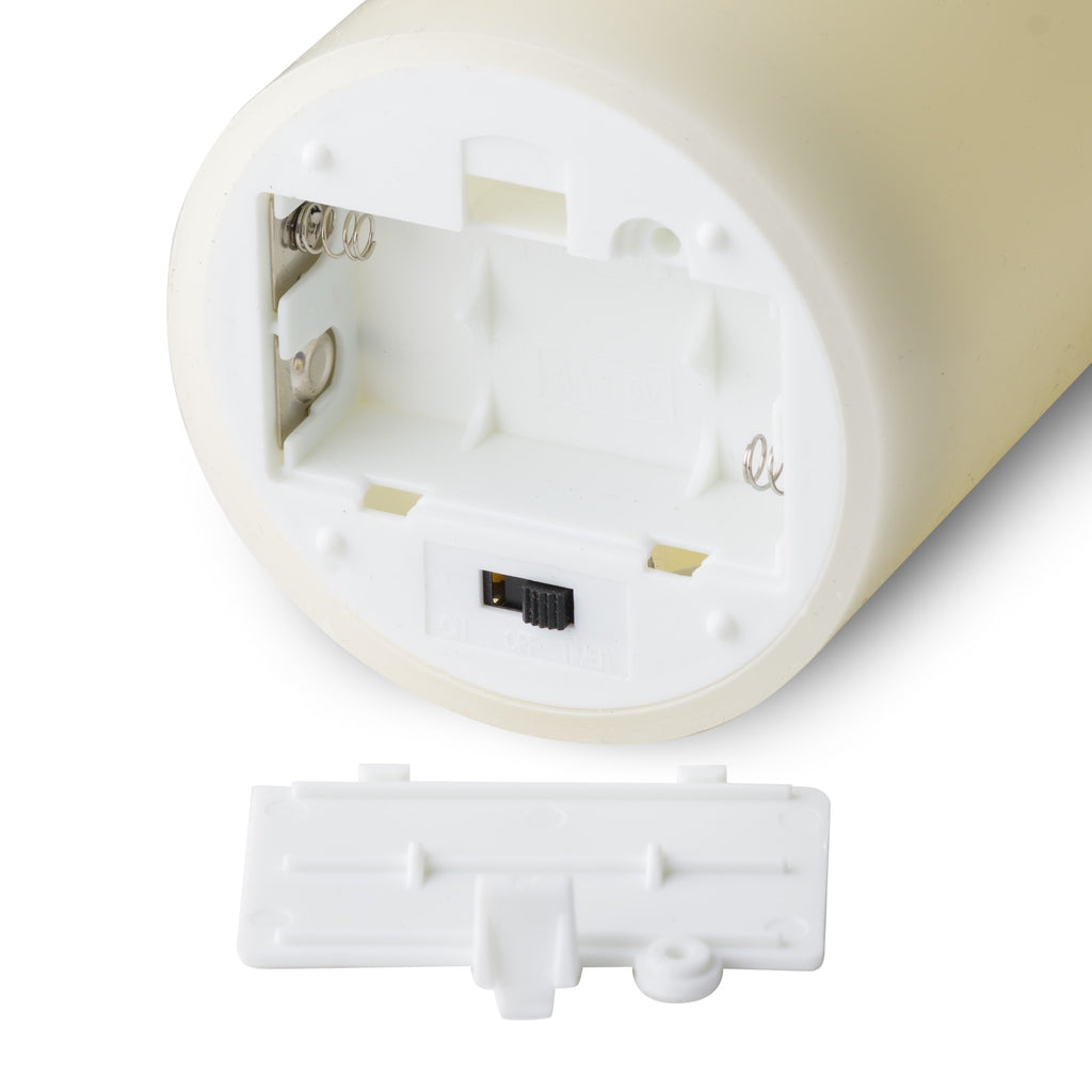Close-up of the candle's underside with the battery compartment open, contacts exposed, sliding switch visible and removable cover alongside.