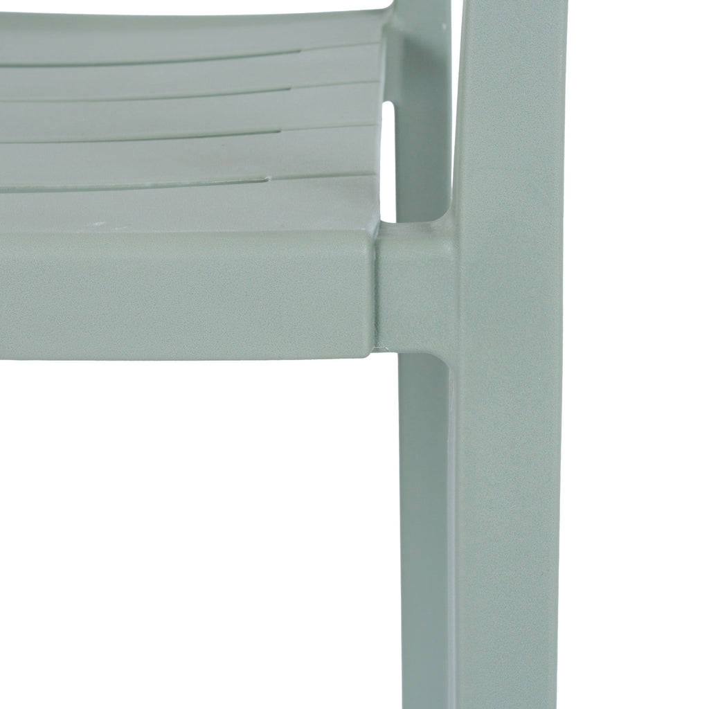 Close-up of the green-grey chair's slatted seat edge and front leg, showing the fine pebbled matte surface.