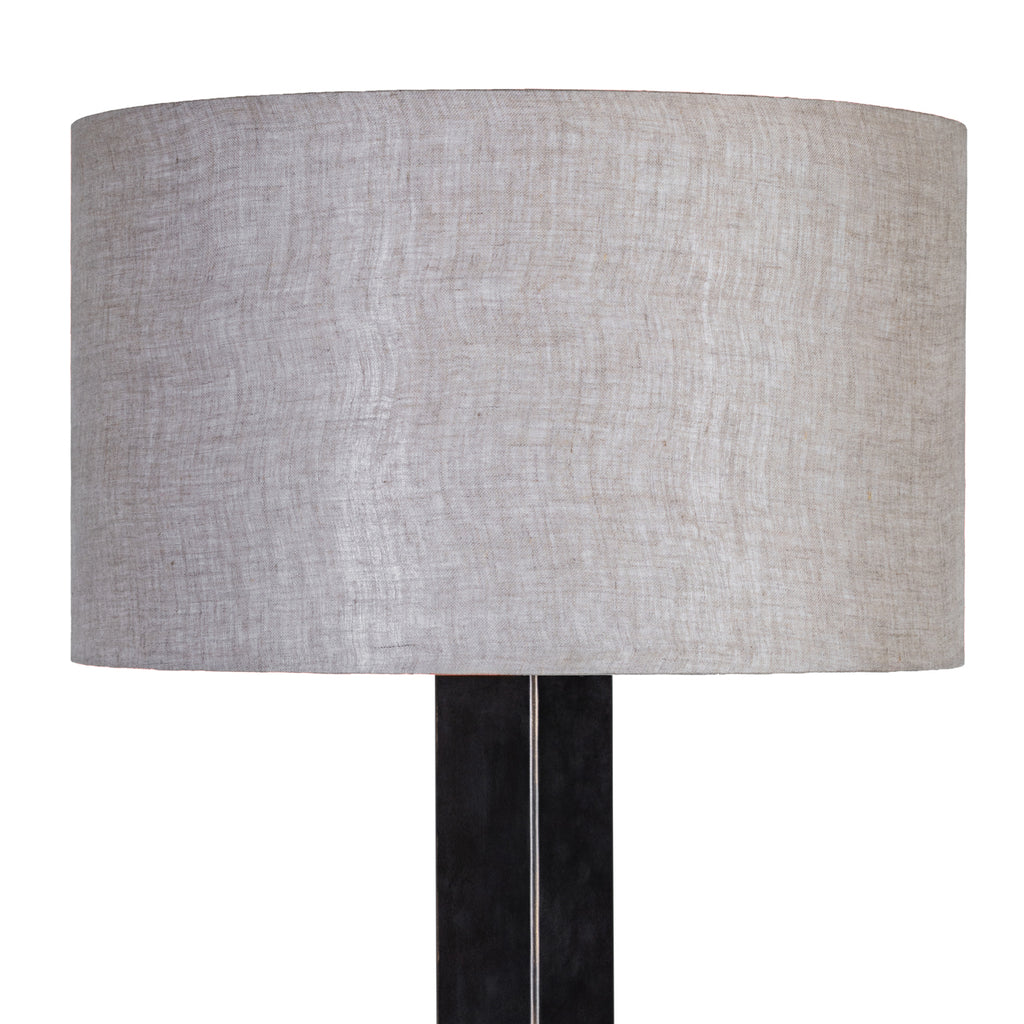 Close-up of the natural-toned drum shade showing its woven fabric texture above the dark lamp stem.