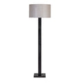 Front view of the floor lamp with a natural fabric drum shade, dark rectangular stem and square base against white.